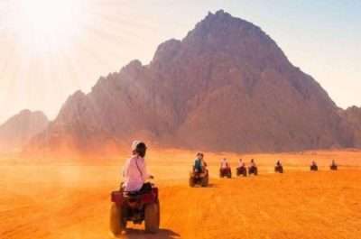 "Tourists riding quad bikes during a sunset desert safari in Luxor, Egypt with Egypt Breeze Tour